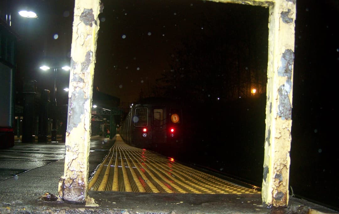An R68 D train departing the station late at night as we prepare to enter the lower level